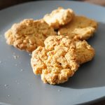 A plate of golden brown, textured Golden Crunch Cookies, showing their crunchy appearance, with a few sugar sprinkles.