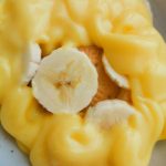 Delicious no-bake Marie Biscuit Dessert with layers of custard, banana, and biscuits in a glass dish, ready to serve
